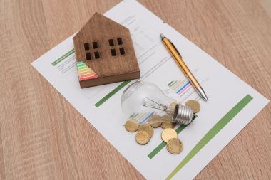 Foto: Glühbirne, Energieskala auf Haus, Münzen